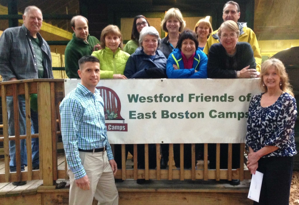 A group of people standing near the camp signage
